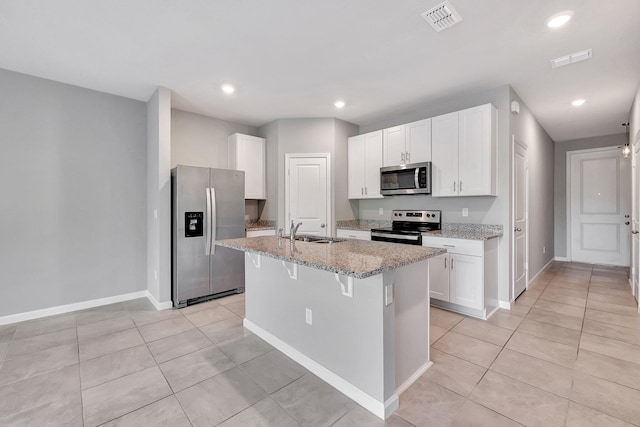 kitchen featuring white cabinets, appliances with stainless steel finishes, sink, and a kitchen island with sink