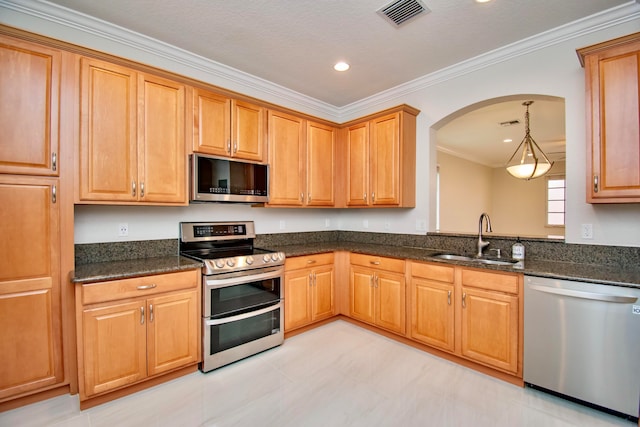 kitchen with pendant lighting, sink, ornamental molding, appliances with stainless steel finishes, and a textured ceiling