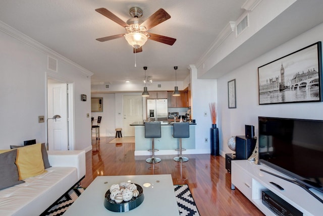 living room featuring light hardwood / wood-style floors, ornamental molding, and ceiling fan