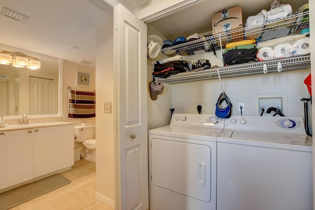 laundry room featuring light tile patterned floors, sink, and washer and dryer