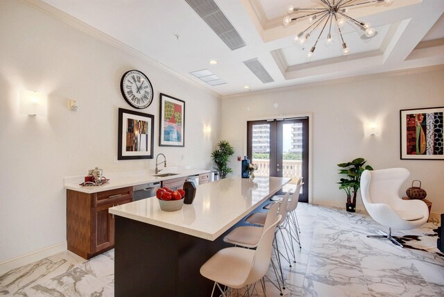 kitchen featuring coffered ceiling, ornamental molding, a center island, and french doors