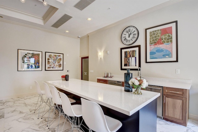 kitchen featuring beamed ceiling, a center island, a breakfast bar area, coffered ceiling, and crown molding