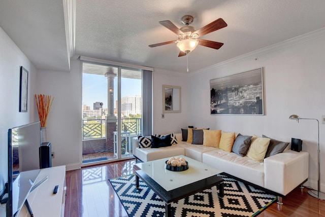 living room featuring wood-type flooring, a textured ceiling, crown molding, and ceiling fan