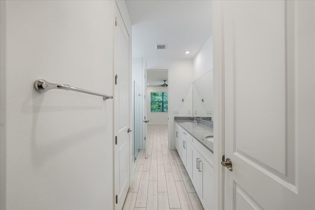 bathroom with wood-type flooring, vanity, and ceiling fan