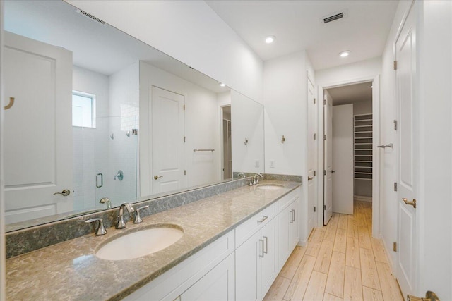 bathroom with vanity, wood-type flooring, and a shower with shower door