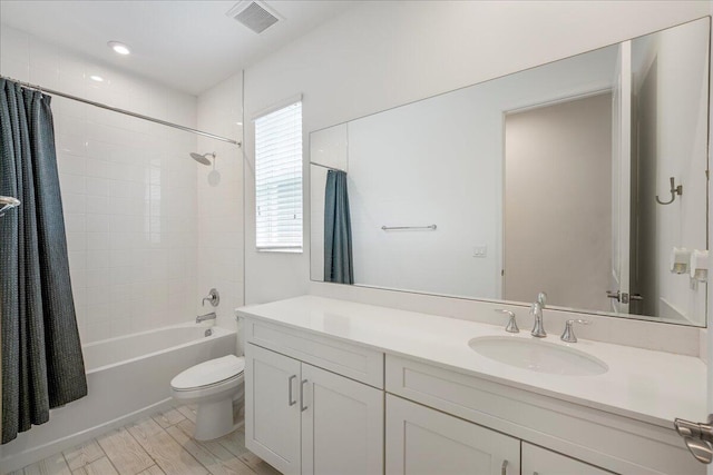 full bathroom featuring wood-type flooring, vanity, shower / tub combo, and toilet