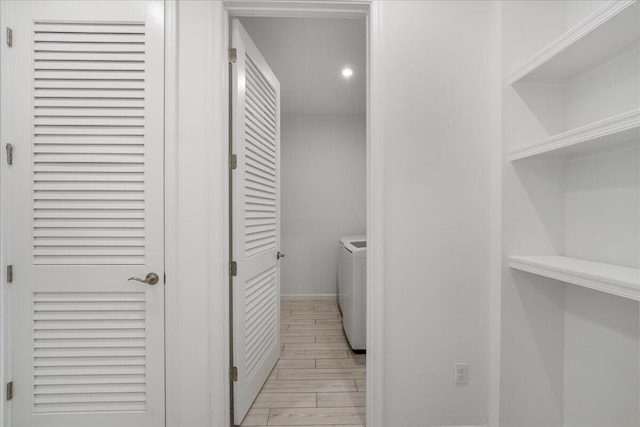 laundry room featuring washer and clothes dryer and light hardwood / wood-style flooring