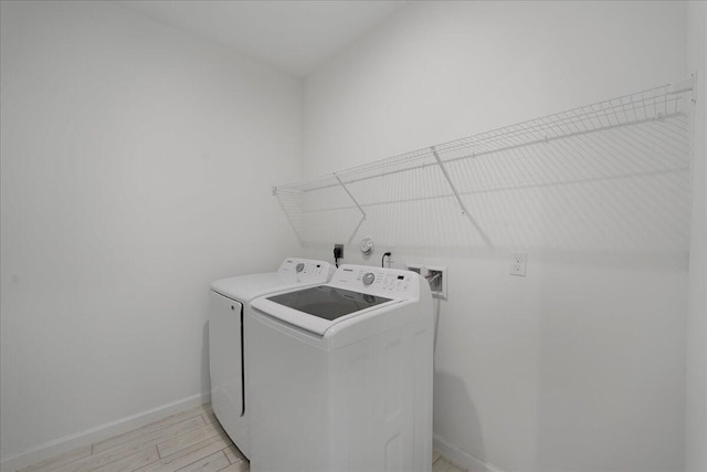 laundry room with light wood-type flooring and washing machine and dryer