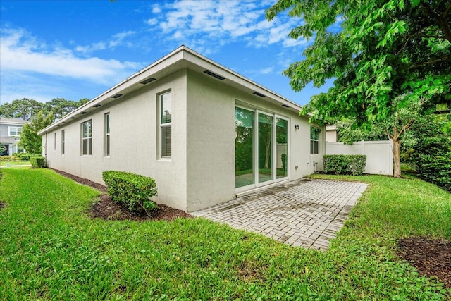 back of house with a yard and a patio area