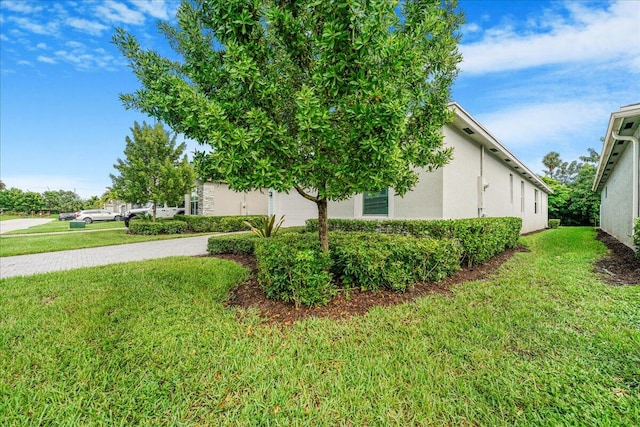 view of side of home featuring a garage and a yard