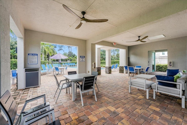 view of patio / terrace with ceiling fan and a pool