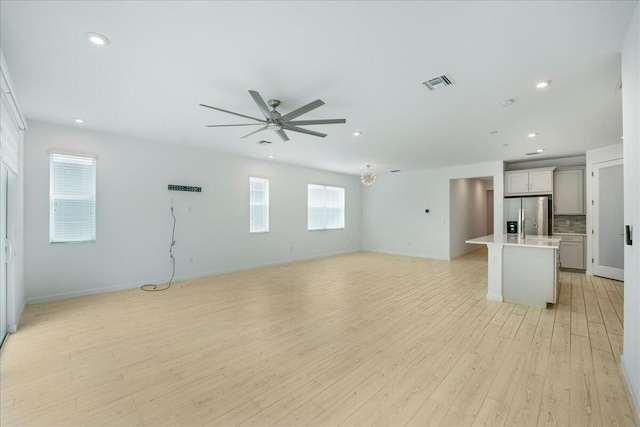 unfurnished living room featuring ceiling fan and light hardwood / wood-style flooring