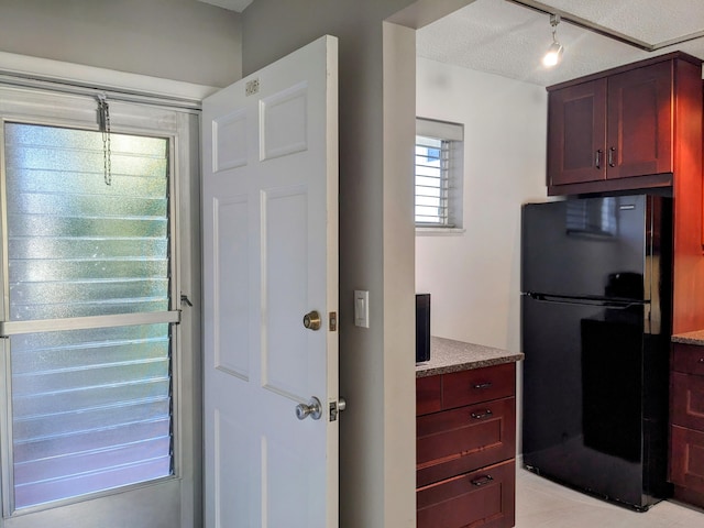 interior space featuring a textured ceiling and black fridge