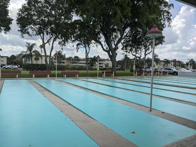 view of pool featuring a lawn