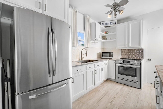 kitchen with decorative backsplash, sink, white cabinets, and appliances with stainless steel finishes