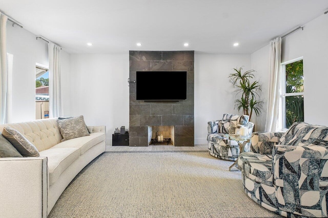 carpeted living room featuring a tile fireplace and plenty of natural light