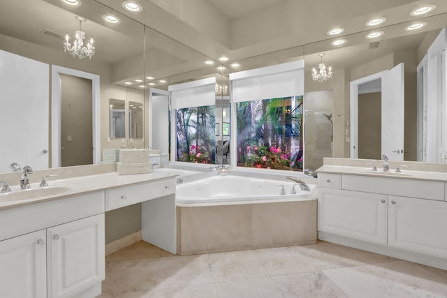 bathroom with tile patterned floors, tiled tub, vanity, and an inviting chandelier