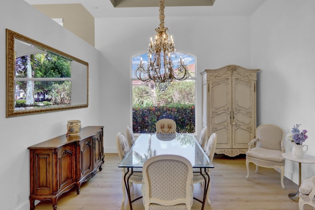 dining room featuring light wood-type flooring and an inviting chandelier