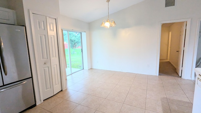 unfurnished dining area featuring a notable chandelier, lofted ceiling, and light tile patterned floors