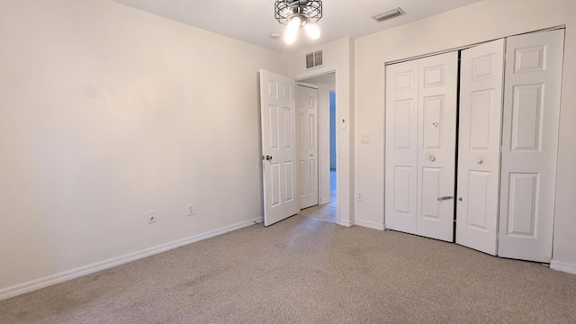 unfurnished bedroom featuring light colored carpet and a closet