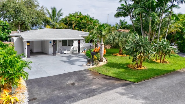 view of front of property with a front yard and a carport