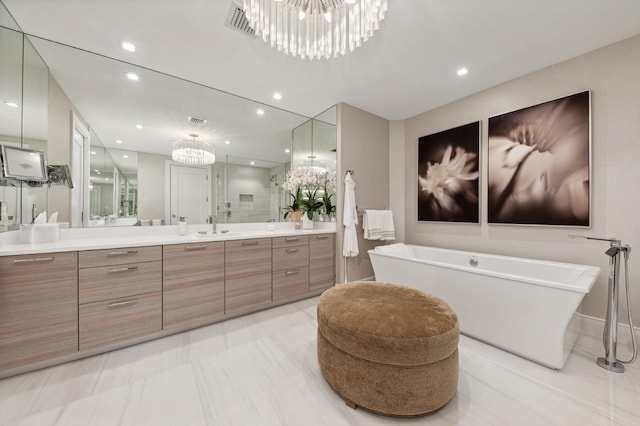 bathroom featuring vanity, a bathing tub, and a notable chandelier