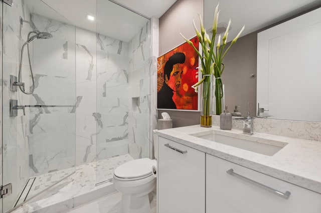 bathroom featuring a shower with door, vanity, and toilet