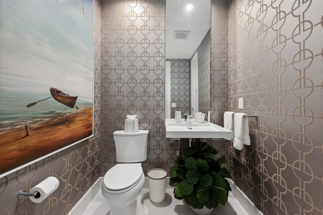 bathroom featuring sink, tile walls, and toilet