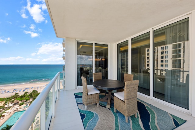 balcony featuring a beach view and a water view