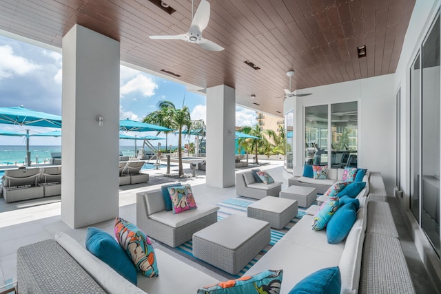 view of patio / terrace featuring ceiling fan, an outdoor living space, and a water view