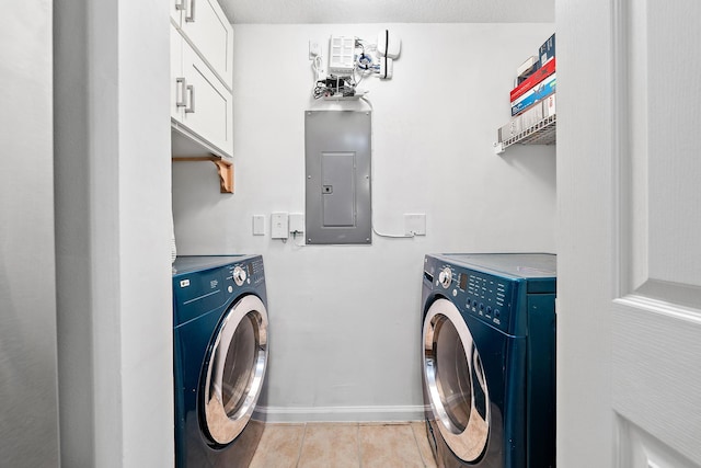 laundry room with electric panel, separate washer and dryer, and cabinets