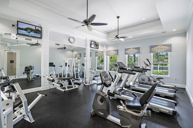 gym with ornamental molding, a tray ceiling, and ceiling fan