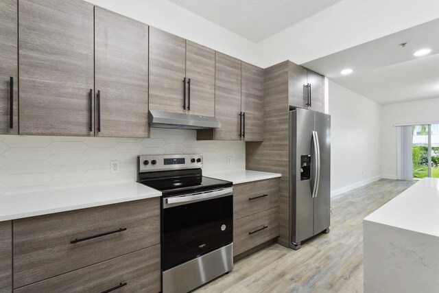 kitchen featuring stainless steel appliances, tasteful backsplash, and light wood-type flooring