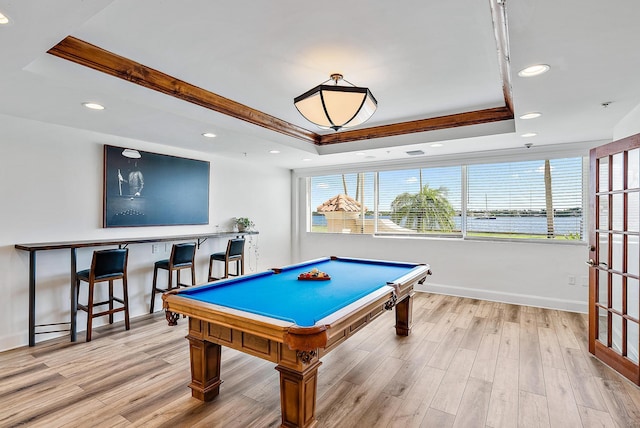 game room featuring light hardwood / wood-style flooring and a raised ceiling