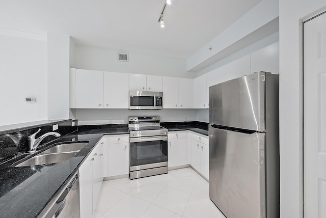 kitchen featuring stainless steel appliances, white cabinetry, sink, and light tile patterned floors