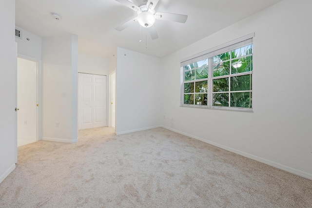 spare room featuring light carpet and ceiling fan