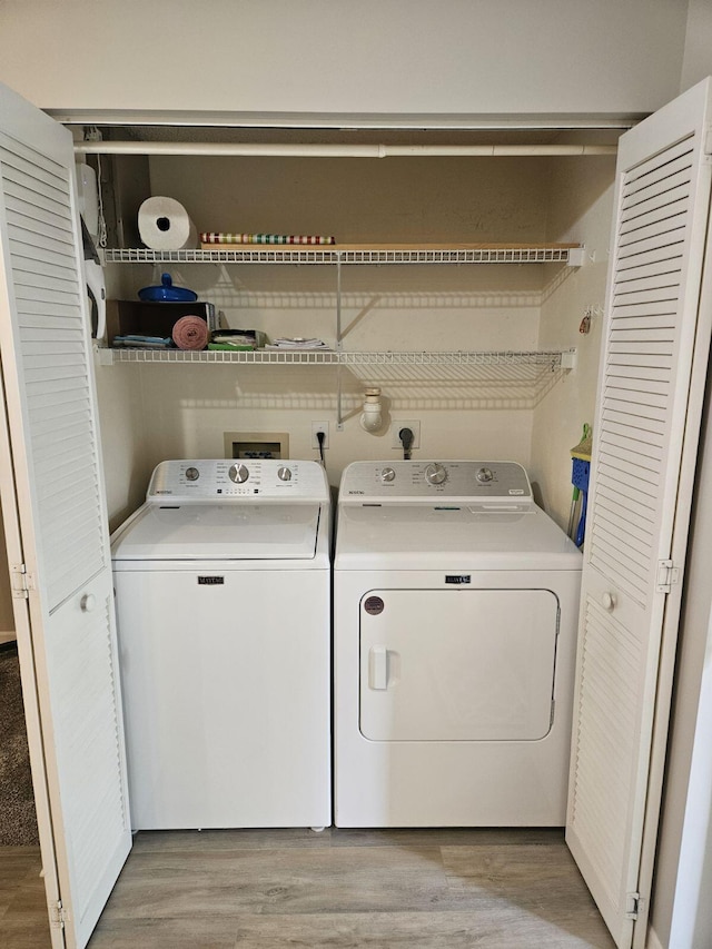 laundry area featuring light wood-type flooring and separate washer and dryer