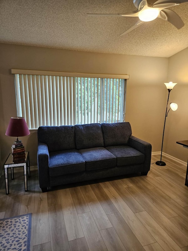 living room featuring a textured ceiling, hardwood / wood-style flooring, and ceiling fan