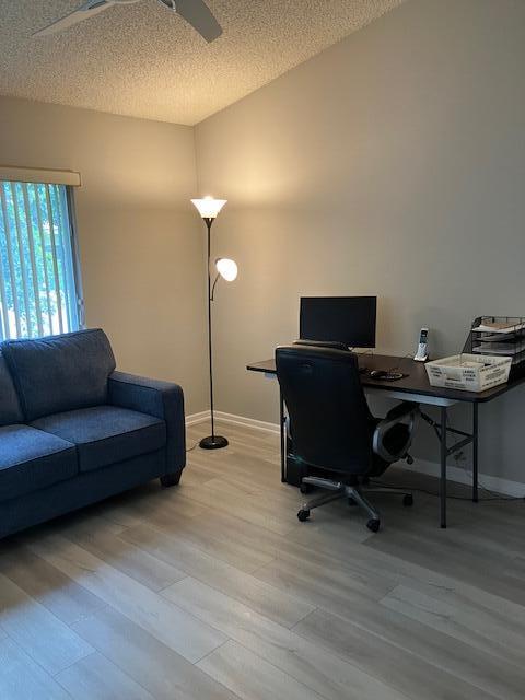 office with a textured ceiling and light wood-type flooring