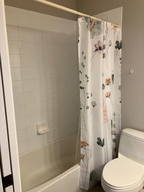 bathroom with shower / tub combo and toilet