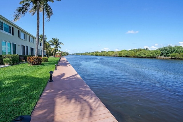 view of dock featuring a water view and a yard