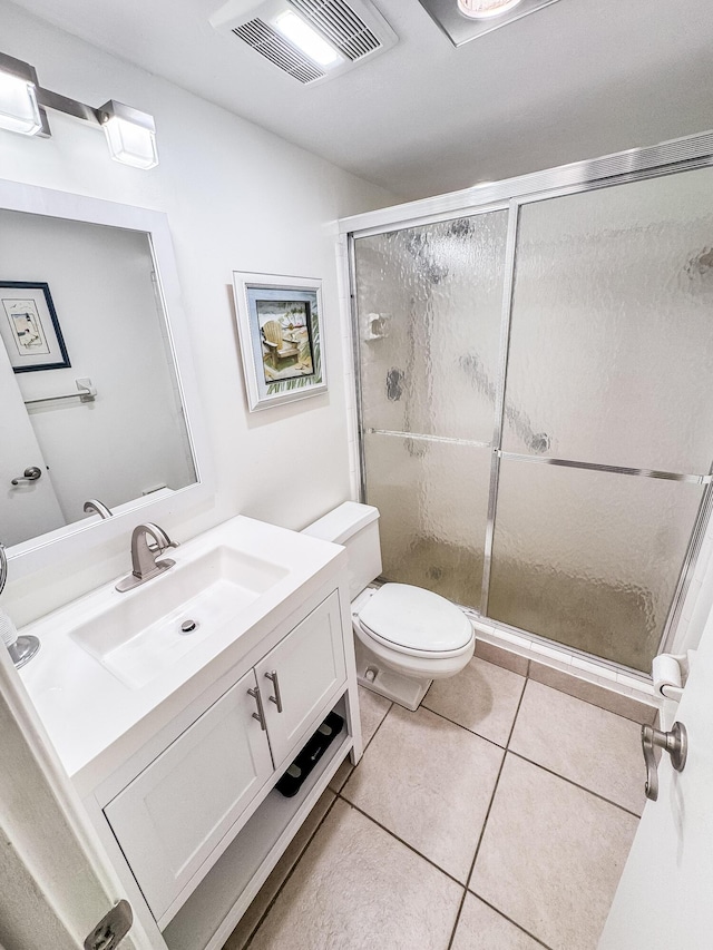 bathroom with toilet, vanity, visible vents, tile patterned floors, and a stall shower