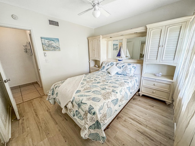 bedroom featuring ceiling fan, light wood-style flooring, and visible vents