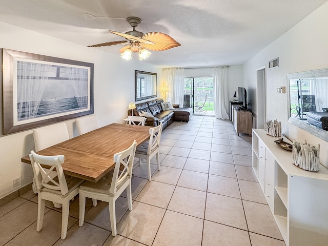 dining space with light tile patterned floors, visible vents, and a ceiling fan