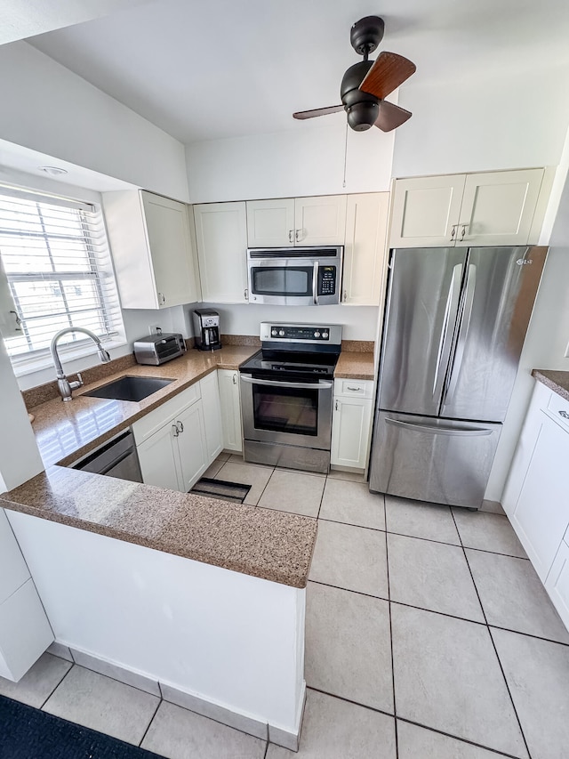 kitchen featuring ceiling fan, kitchen peninsula, sink, and appliances with stainless steel finishes