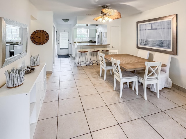 dining room featuring light tile patterned flooring, ceiling fan, and baseboards