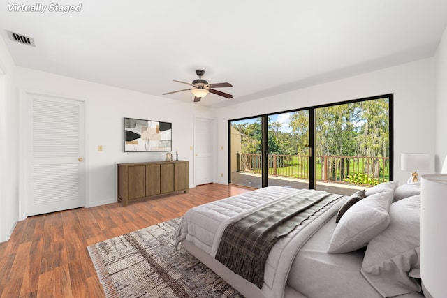 bedroom with dark wood-type flooring, access to outside, and ceiling fan