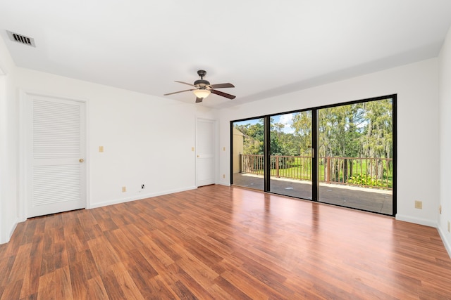 empty room with hardwood / wood-style floors and ceiling fan