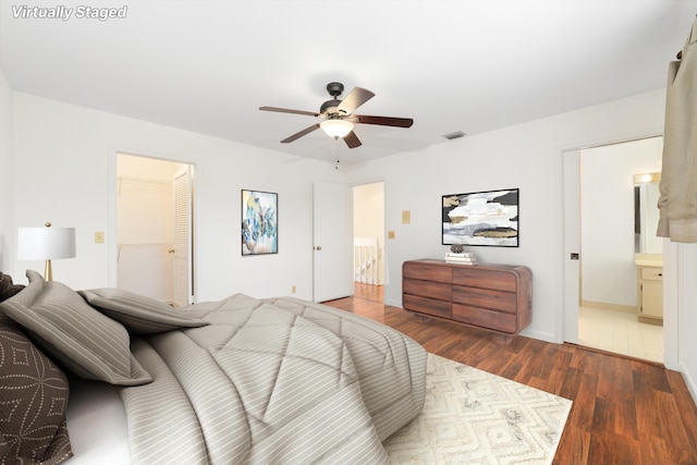 bedroom featuring ceiling fan, ensuite bathroom, and dark hardwood / wood-style flooring