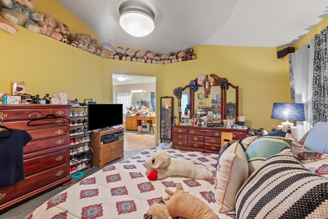 bedroom with light colored carpet and vaulted ceiling